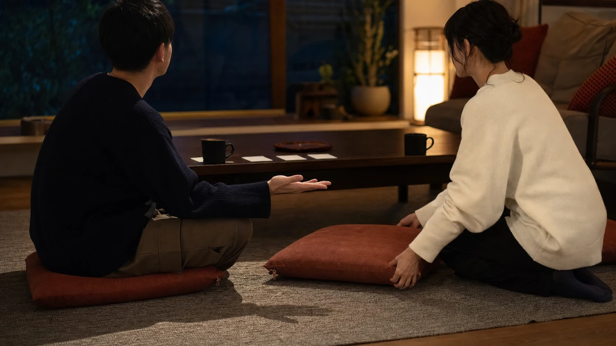 赤い蛇の恋愛に必要な安心できる距離として、二人がソファの間隔と予定を表す無地カードを一緒に調整し、片方が近づく前に手の合図で確認している場面